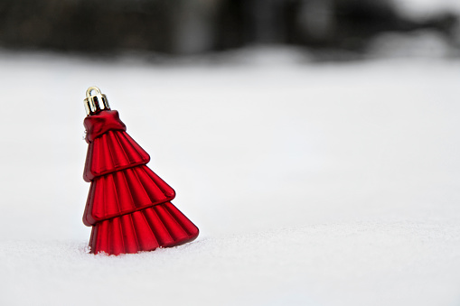 Red fir tree decoration on real snow. Happy new year concept. Write your message. Copy space.