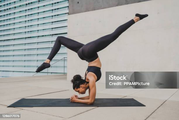 Woman Exercising In Front Of A Wall Stock Photo - Download Image Now - Yoga, Outdoors, Women