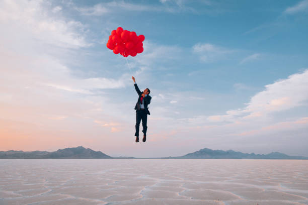 empresario volando con globos - pleasure launch fotografías e imágenes de stock
