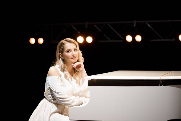 istock Pianist posing near white piano on the stage 1286019831