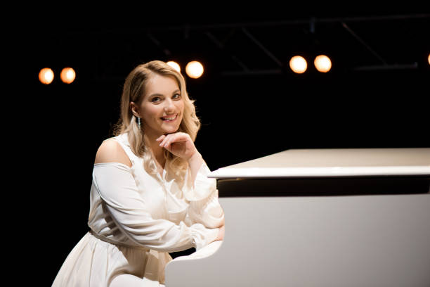 istock Pianist posing near white piano on the stage 1286019836