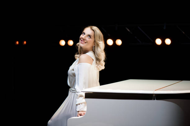 istock Pianist posing near white piano on the stage 1286019861