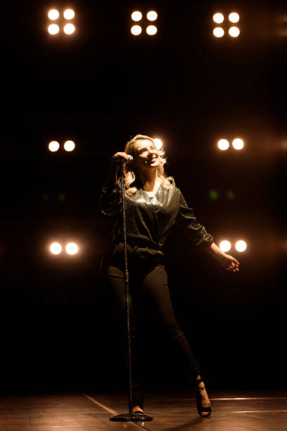 istock Vocalist singing to microphone. Singer in silhouette 1286019893