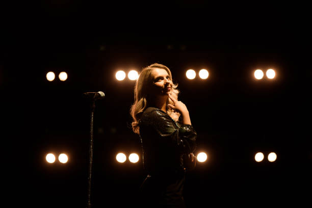 istock Vocalist singing to microphone. Singer in silhouette 1286019908
