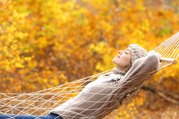 istock Relaxed woman lying on hammock in autumn forest 1286022369