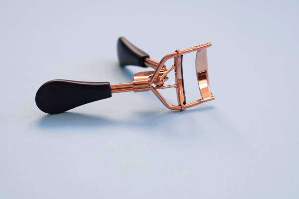 istock Eyelash curler with black handles on a blue background, close up 1286022481