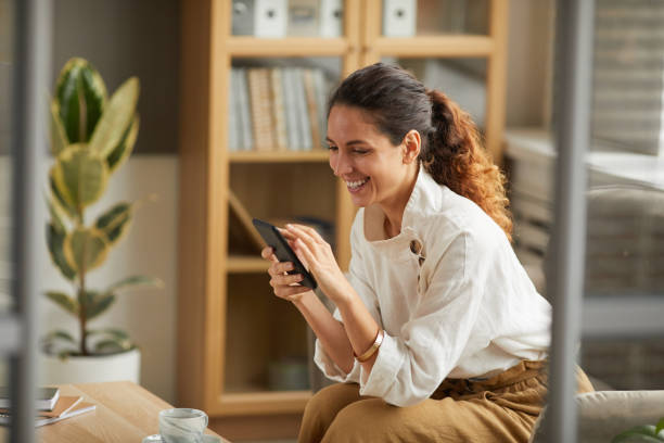 istock Smiling Businesswoman Looking at Smartphone Screen 1286023796