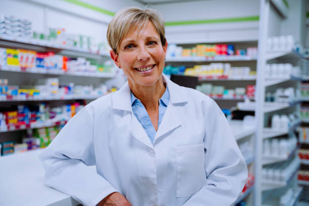 istock Smiling senior pharmacist looking happy leaning against medication counter standing in pharmacy 1286024690