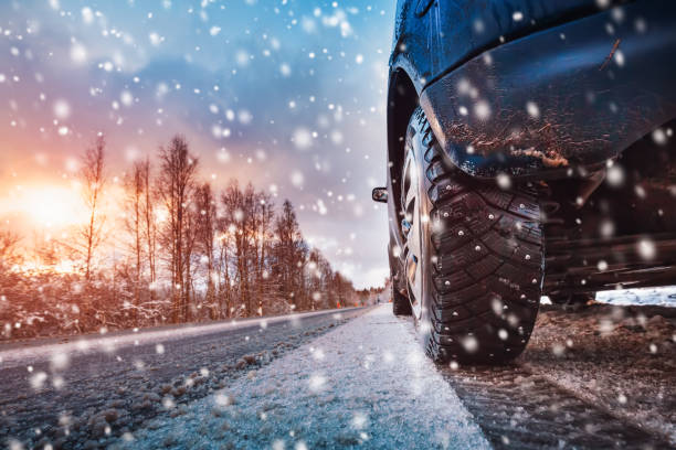 car tires on winter road covered with snow - winter driving imagens e fotografias de stock