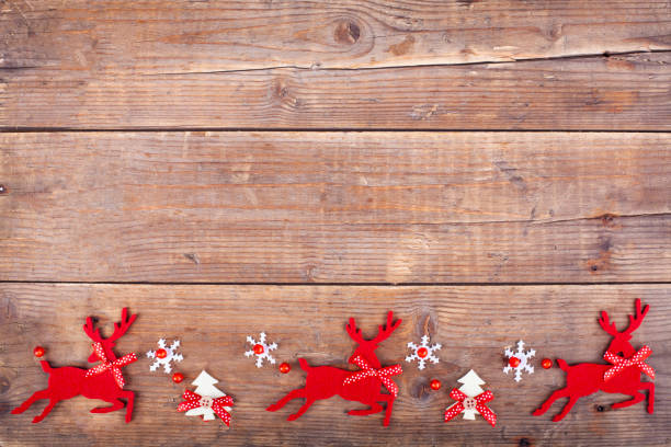 istock Christmas decoration deers, christmas tree and snowflake on rustic wooden table 1286026159