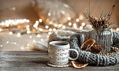 Cozy composition with a Christmas cup on a blurred background with lights.