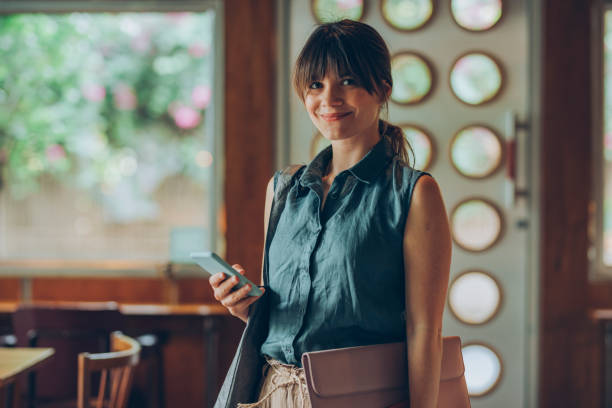 Telecommuting: Beautiful Young Freelancer Holding Entering a Cafe with her Work Essentials in her Hands