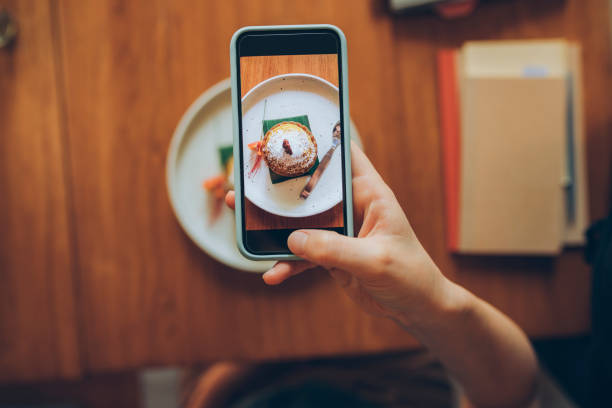 mão de uma jovem anônima tirando uma foto de sua deliciosa especiaria de abóbora para postar nas redes sociais - food photography - fotografias e filmes do acervo