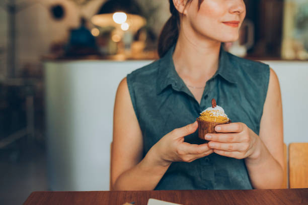 istock Anonymous Smiling Female Student Making a Short Study Break to Enjoy a Delicious Pumpkin Spice Cupcake 1286034593