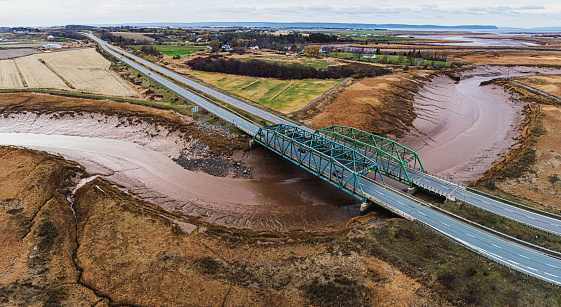 Aerial drone view of a four lane highway crossing a tidal river.