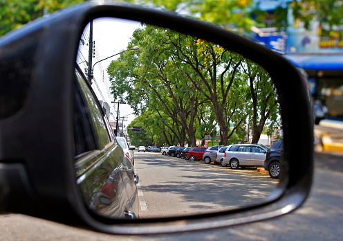 View of many cars parked by the rear view mirror in a small city in Brazil.