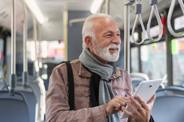 istock Elderly man using mobile digital tablet while traveling in bus. Male passenger is commuting by public transport. 1286042302