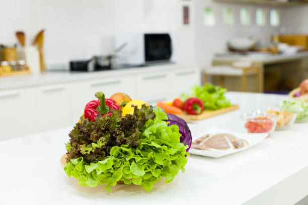 The ingredients for making salad are placed on the table in kitchen.