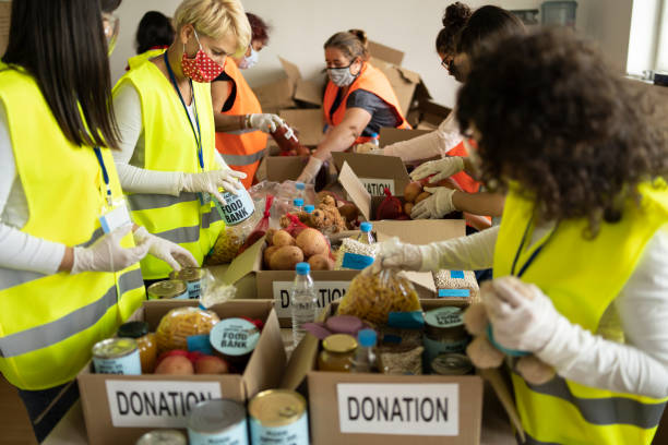 arrecadação de alimentos para doação em um abrigo para sem-teto - charity and relief work volunteer assistance food - fotografias e filmes do acervo