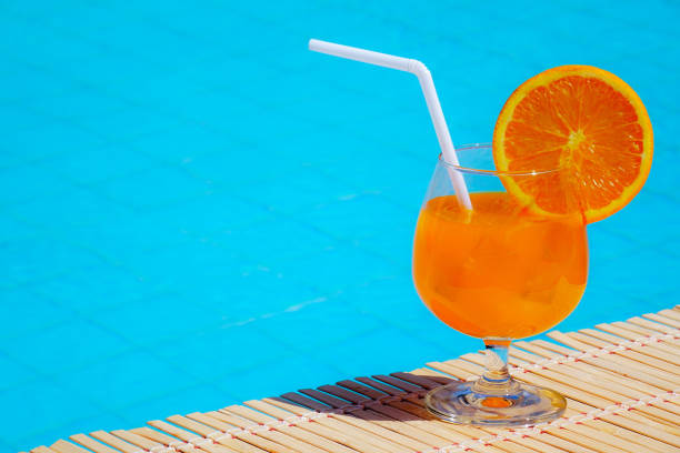 istock freshness orange juice drinking on swimming pool. 1286049240