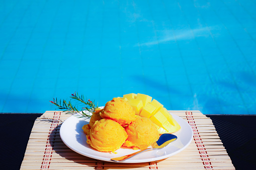 homemade mango ice cream on swimming pool.