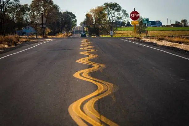 Photo of wavy road lane lines on empty Idaho road