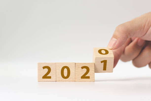istock New year 2020 change to 2021 concept. Hand flip over wood cube block 1286060942