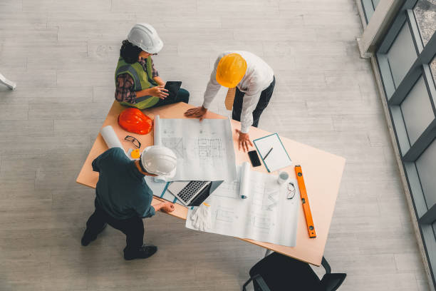 istock Team of engineers and architects working, planing, measuring layout of building blueprints in construction site. top view 1286062006