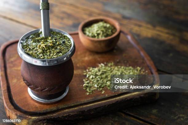 Traditional Argentinian Yerba Mate Tea In A Calabash Gourd With Bombilla Stick Against Wooden Background Stock Photo - Download Image Now