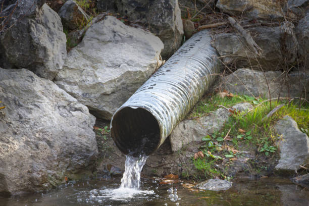 istock Water Flowing out of Pipe into Creek 1286063483