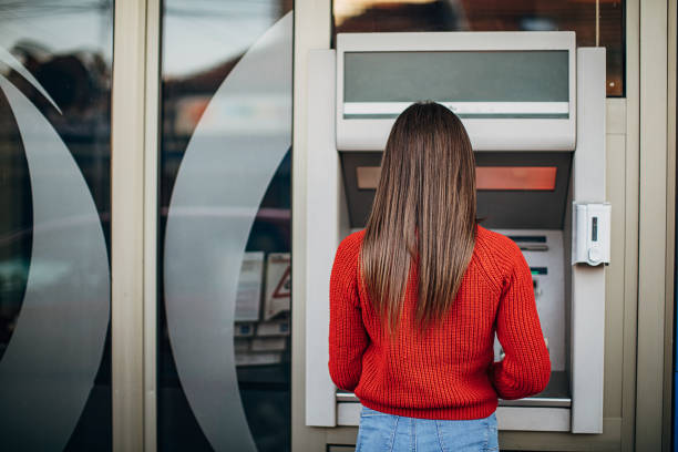 istock Woman using ATM machine on the street 1286070116