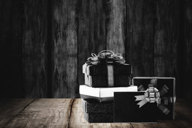 istock Stack of colorful gift box with black ribbon on wooden background 1286074757