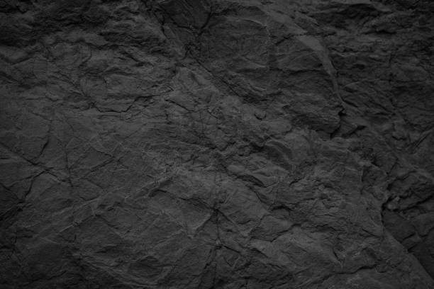 istock Black stone background. Dark gray rock texture. Rough stone surface with cracks. 1286076569