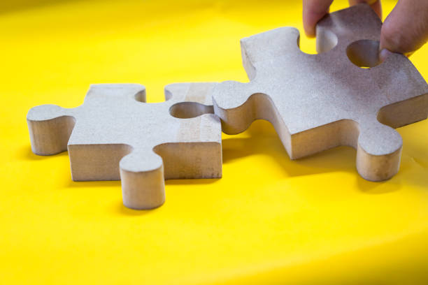 istock jigsaw puzzle pieces for teamwork on yellow paper background, teamwork put pieces together to connect cooperation. Business team work solutions in success or strategy concept 1286077280