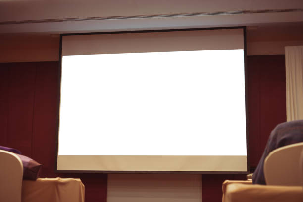 istock Seminar room with blank projector empty white screen for presentation in conference or meeting room, Business meeting and education in teaching classroom concept 1286077286