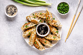 Fried dumplings gyoza with soy sauce, and chopsticks, top view