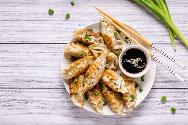 istock Fried dumplings gyoza with soy sauce, and chopsticks, top view 1286079825