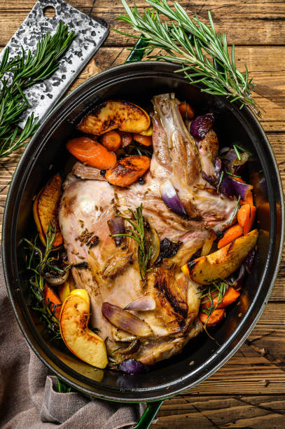 istock Stewed whole lamb shoulder in a baking dish.  Wooden background. Top view 1286082641