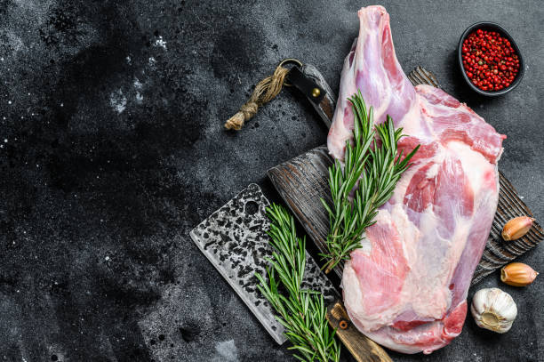 istock Raw lamb shoulder meat ready for baking with garlic, rosemary. Black background. Top view. Copy space 1286082828