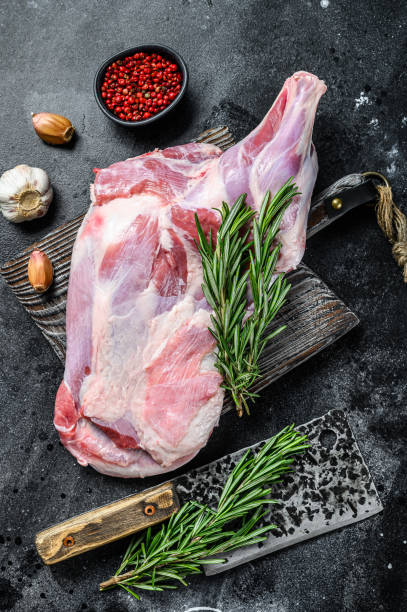 istock Raw lamb shoulder meat ready for baking with garlic, rosemary. Black background. Top view 1286082832
