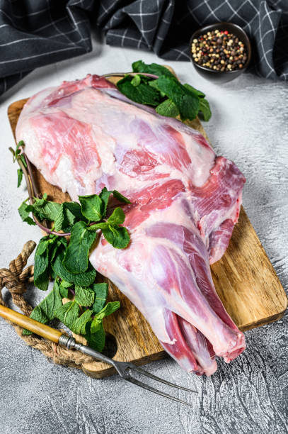 istock Raw goat shoulder meat ready for baking with garlic, mint. White background. Top view 1286082855