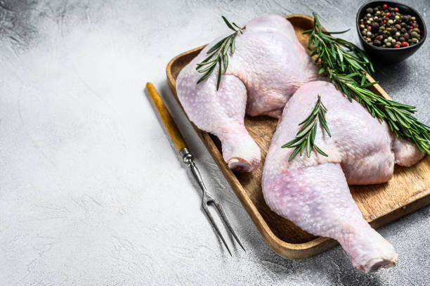istock Raw chicken legs on a cutting board. White background. Top view. Copy space 1286082859