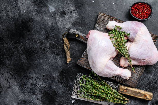 istock Fresh raw chicken legs on a cutting board. Black background. Top view. Copy space 1286082944