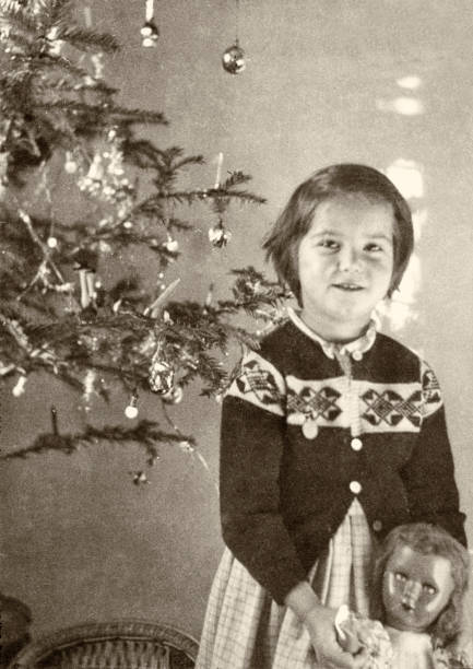 istock Child with doll under christmas tree. 1955. 1286084485