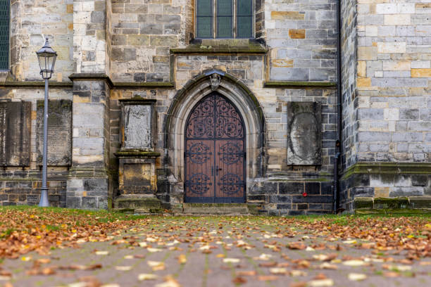 Portal of ancient abbey in Switzerland, Solothurn, with evening light. Two old lime trees border the portal's outer edges.