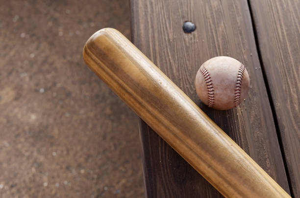 bate de béisbol, y pelota en el banquillo dugout. - wooden bat fotografías e imágenes de stock