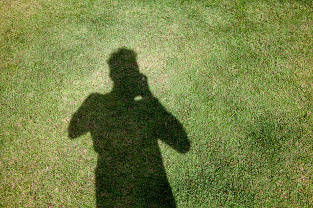 istock Photographer Taking A Shadow Selfie On Green Grass Field 1286095158