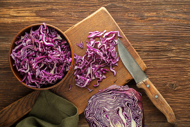 Red cabbage Cut red cabbage on chopping board on wooden background, top view. Vegetarian, slimming, diet food concept. cabbage stock pictures, royalty-free photos & images