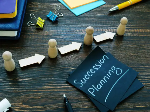 Photo of Succession planning and figurines with arrows.