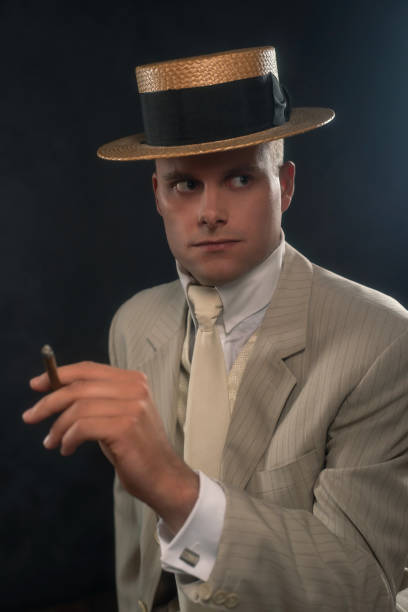 istock Man wearing boater hat and suit smoking cigar. 1286097928